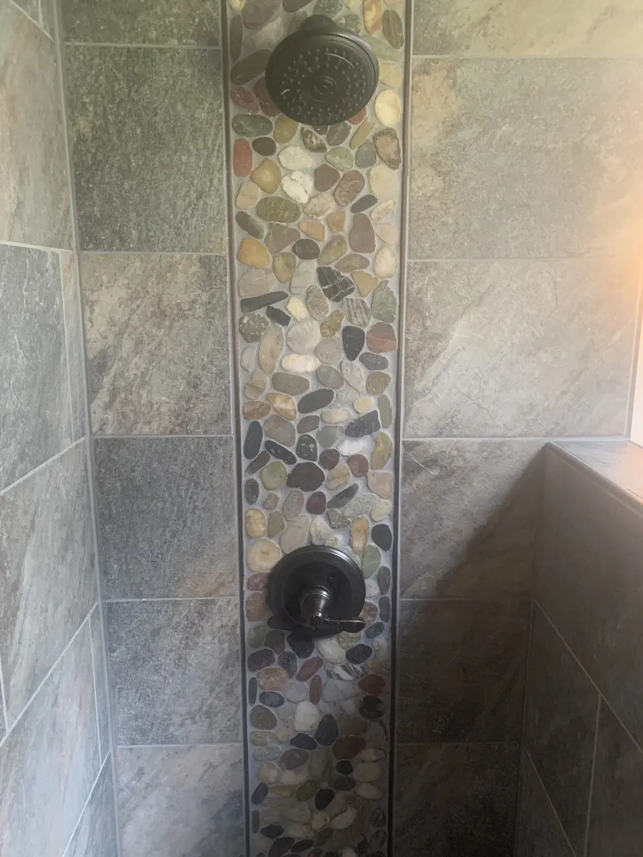 Shower with a shower head and rocks